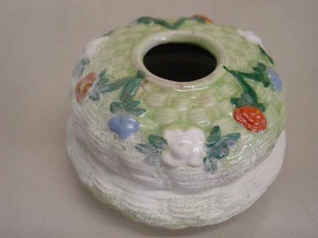 A small pot with a hole in the lid