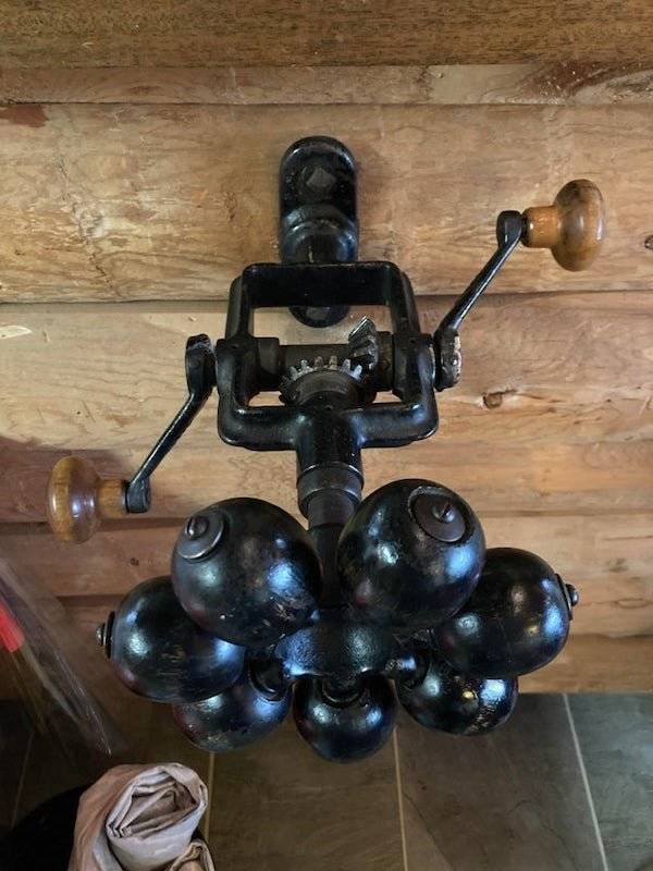 A wall-mounted device with spinning arms and wooden balls