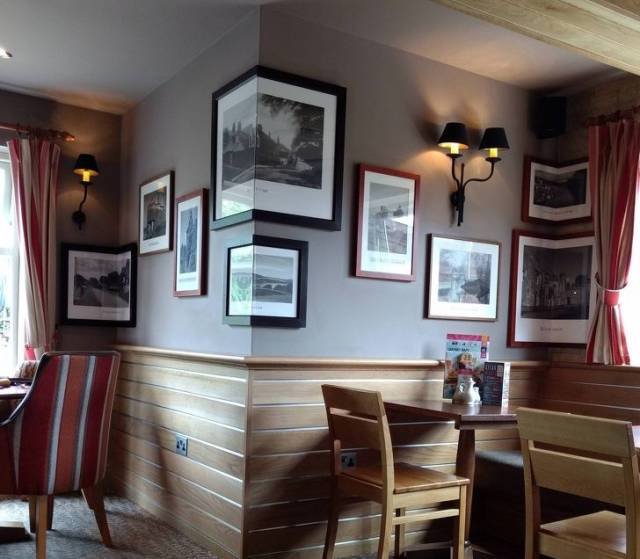 Photos hung on a wall in a chaotic layout